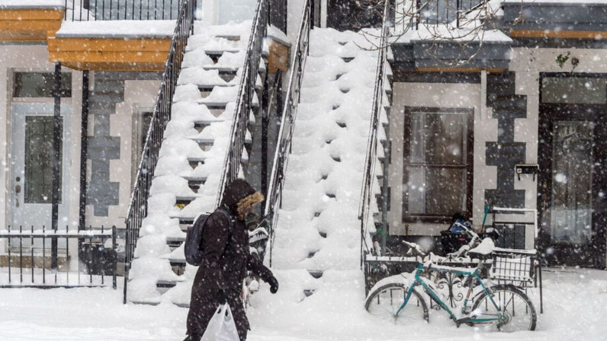 Snowstorm in Montreal. Pedestrian walking on a sidewalk.
