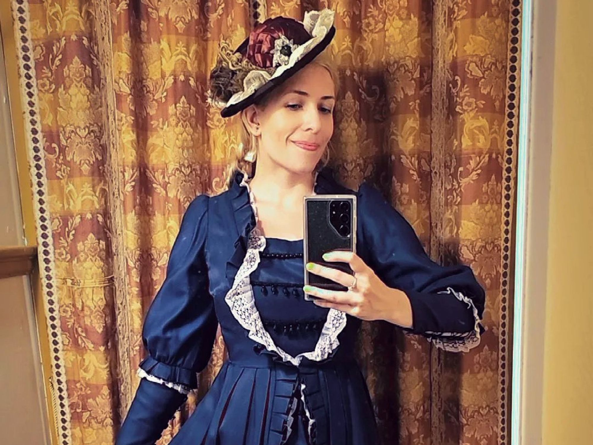 Sofia wearing a brown silk hat blue and tafetta dress with lace trim and beading.