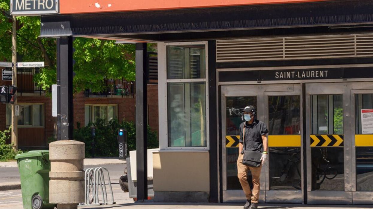 Someone exits St-Laurent metro station wearing a face mask.