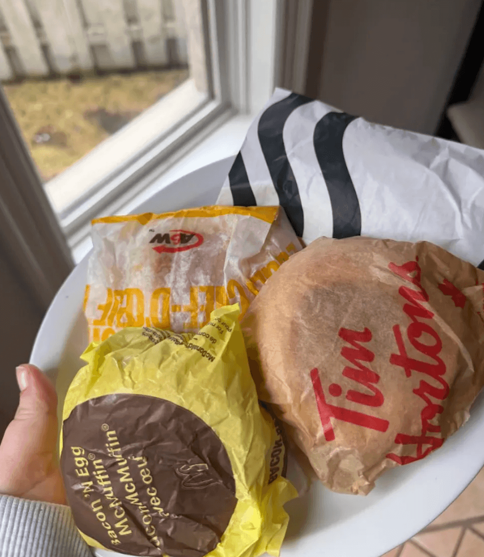 Someone holding a breakfast sandwich.