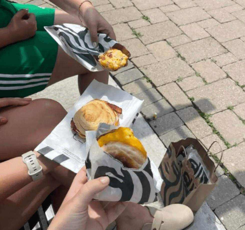 Someone holding a breakfast sandwich.