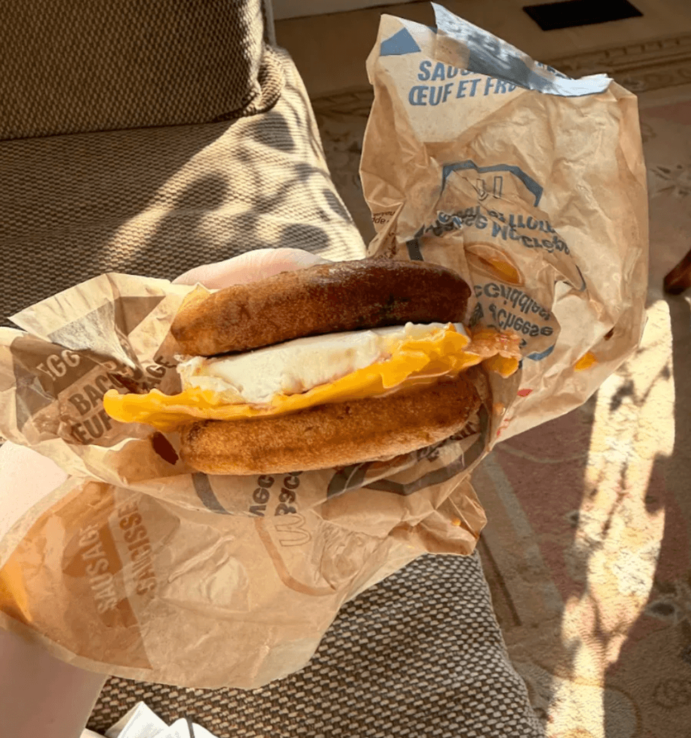 Someone holding a breakfast sandwich.