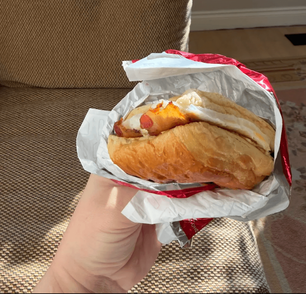 Someone holding a breakfast sandwich.