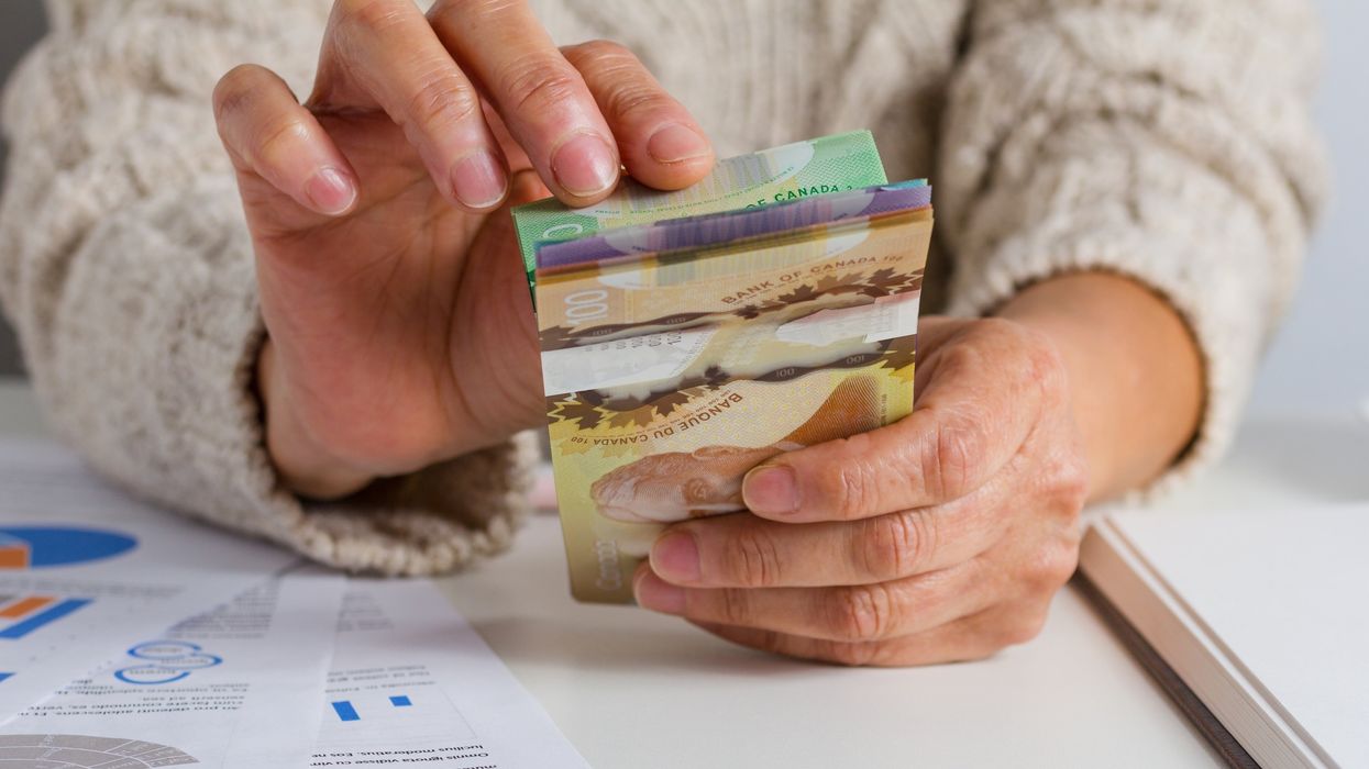 Someone holding a stack of Canadian bills (illustrative).