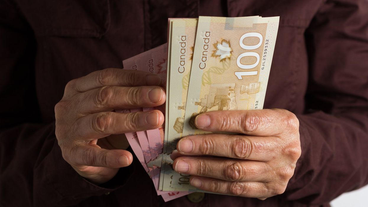 Someone holding Canadian banknotes (illustrative).