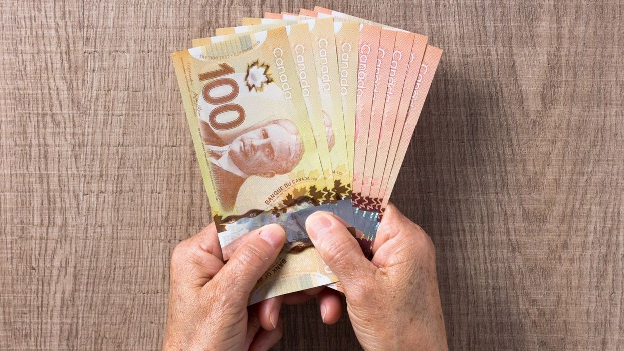 Someone holding Canadian banknotes.