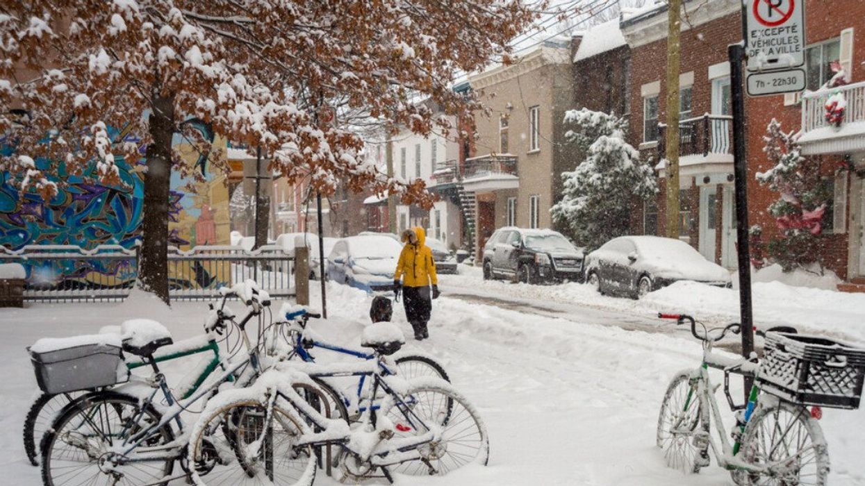 Someone in a yellow coat walks through the Plateau after a snowstorm.
