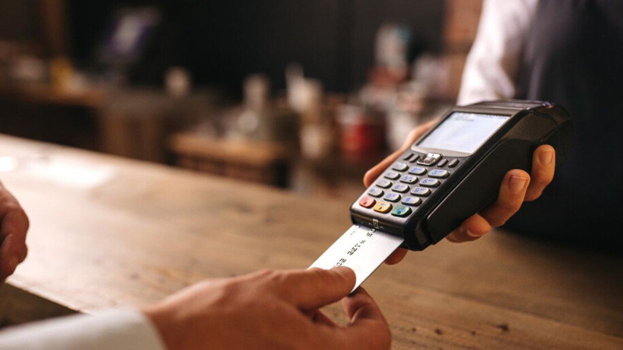 Someone inserts a card into a reader to pay at a bar.