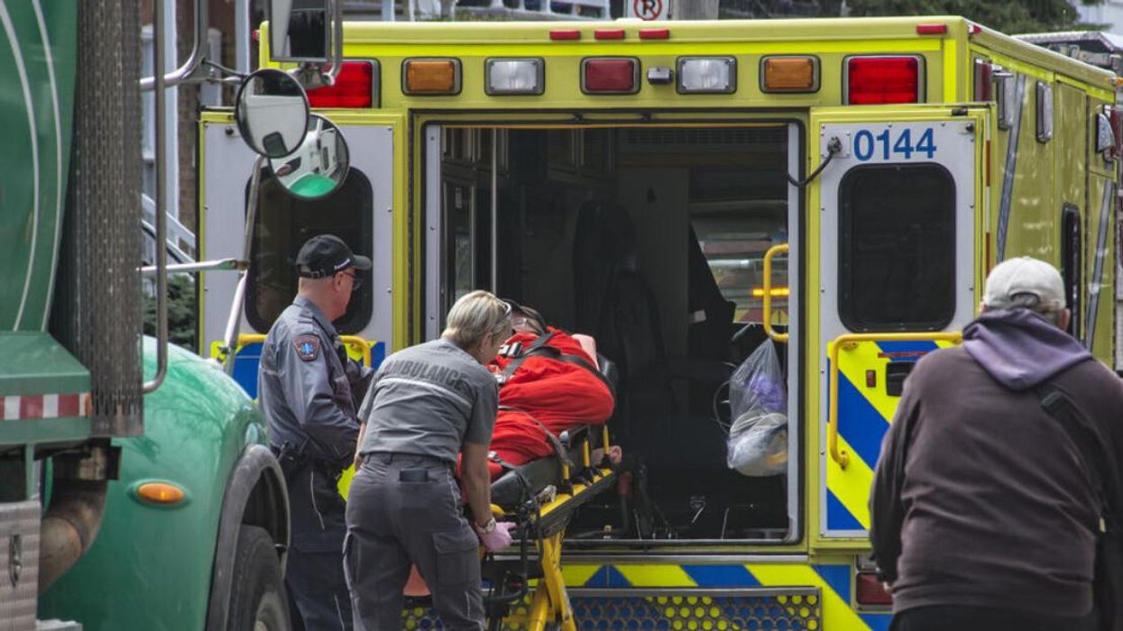 Someone on a stretcher is lifted into a Montreal ambulance by paramedics.