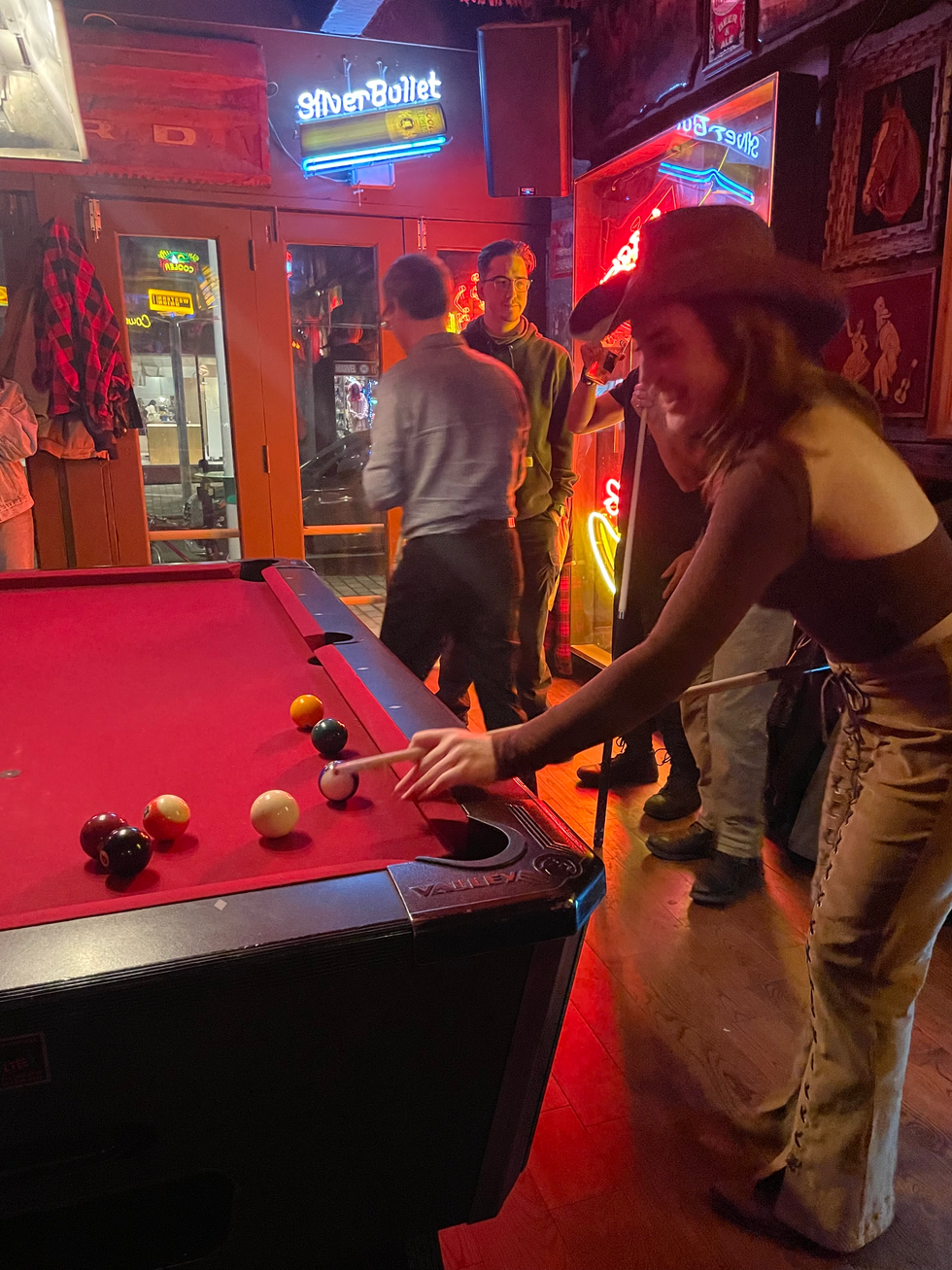 Someone plays pool in a cowboy hat.