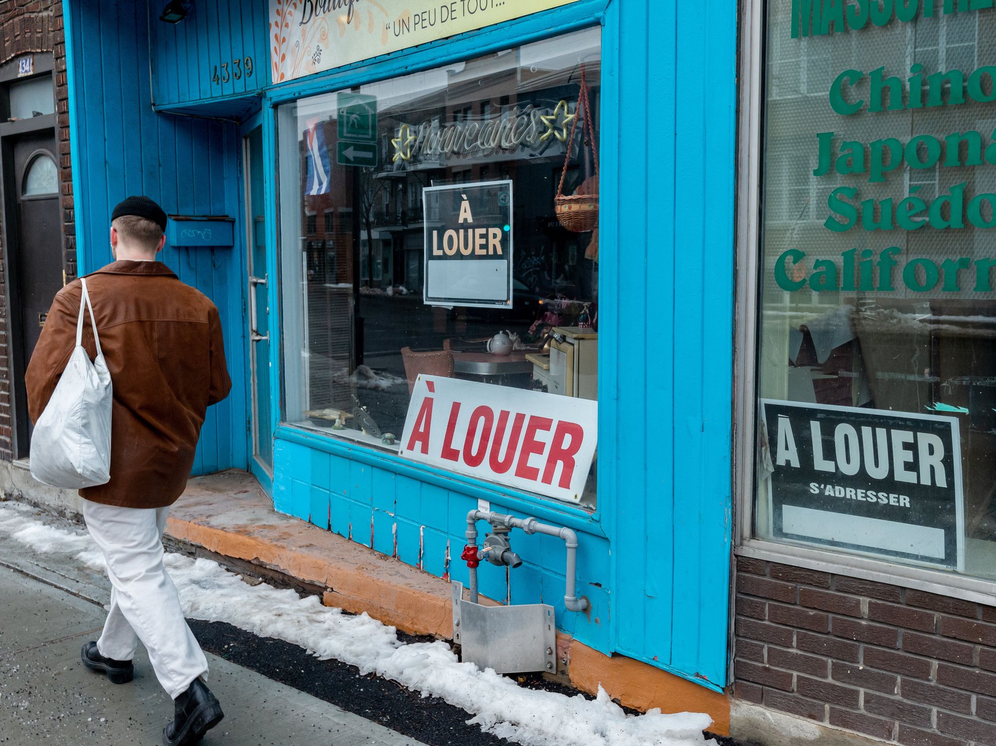 Someone walks past "For Rent" signs in Montreal.