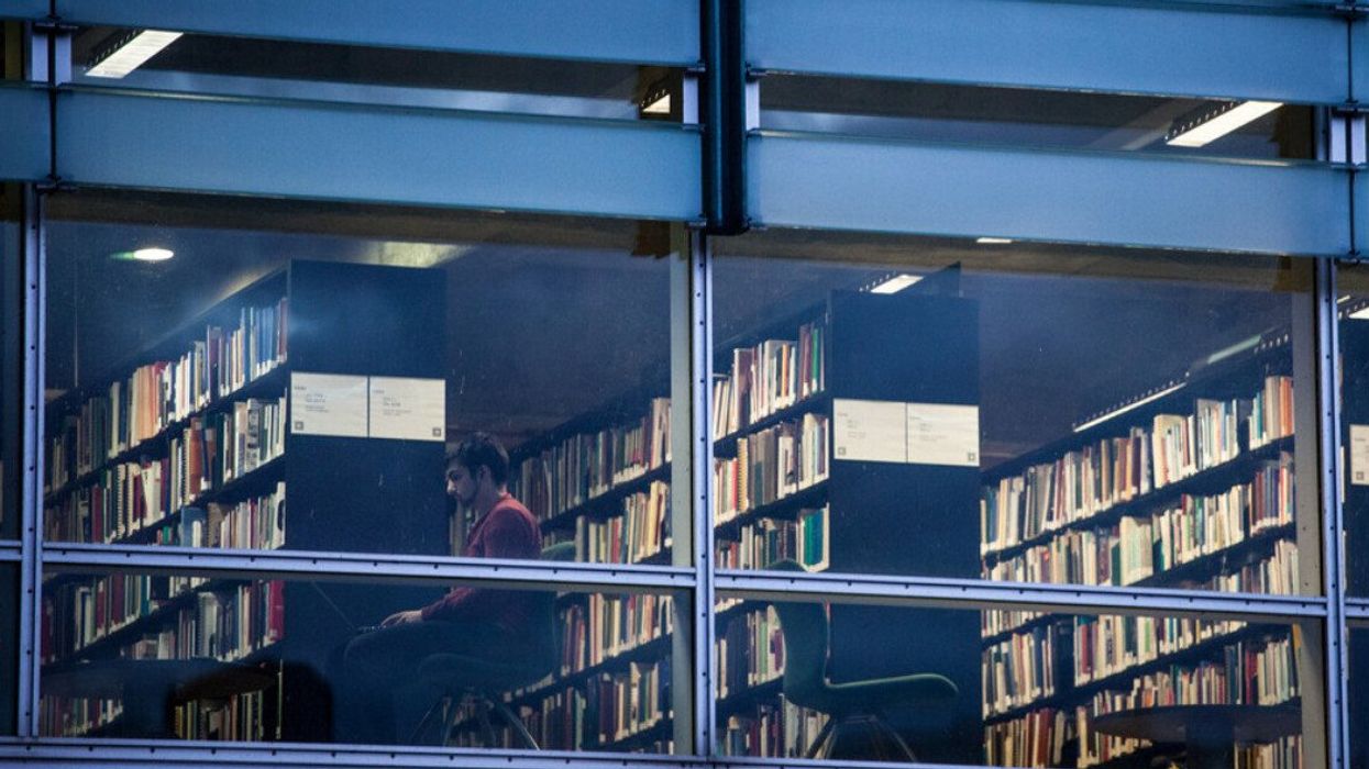 Someone wears headphones sitting at a desk in a Montreal library.