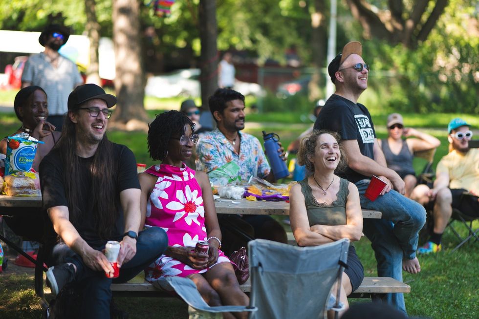 Spectators laugh along to a comedy show in a Montreal park.