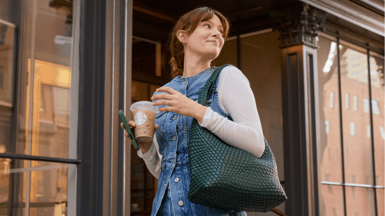 Starbucks customer smiling with iced drink in hand.