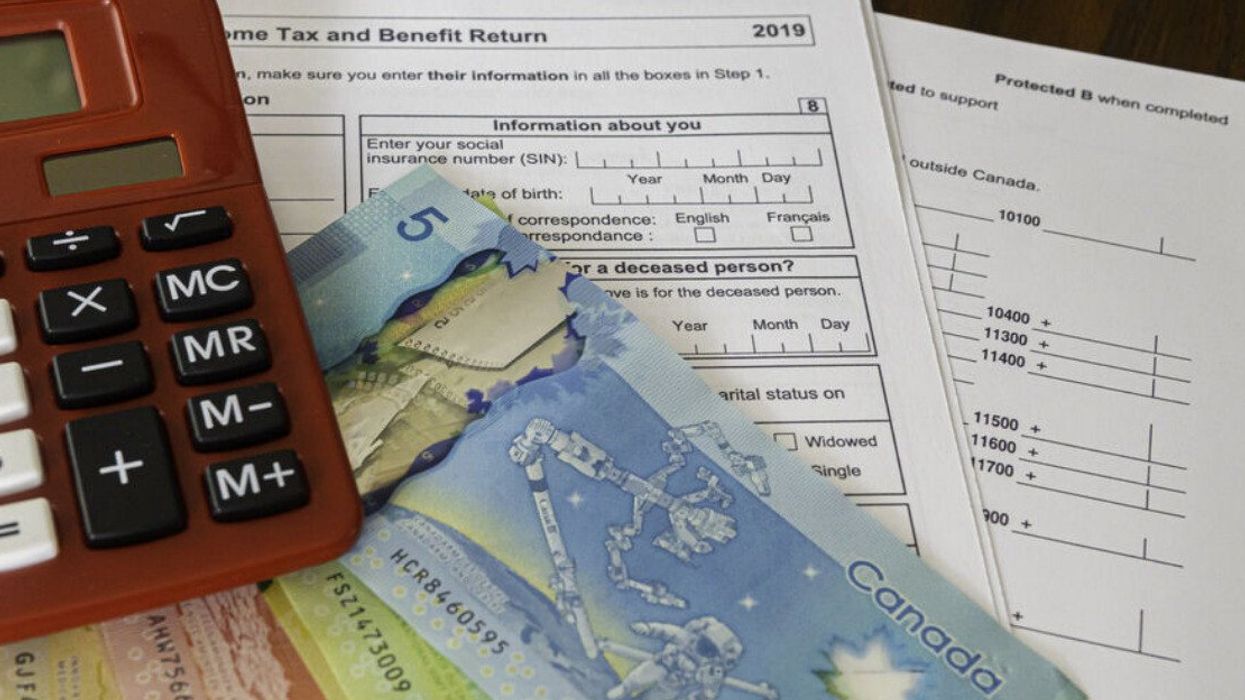 Tax forms with red calculator to prepare taxes for a client.