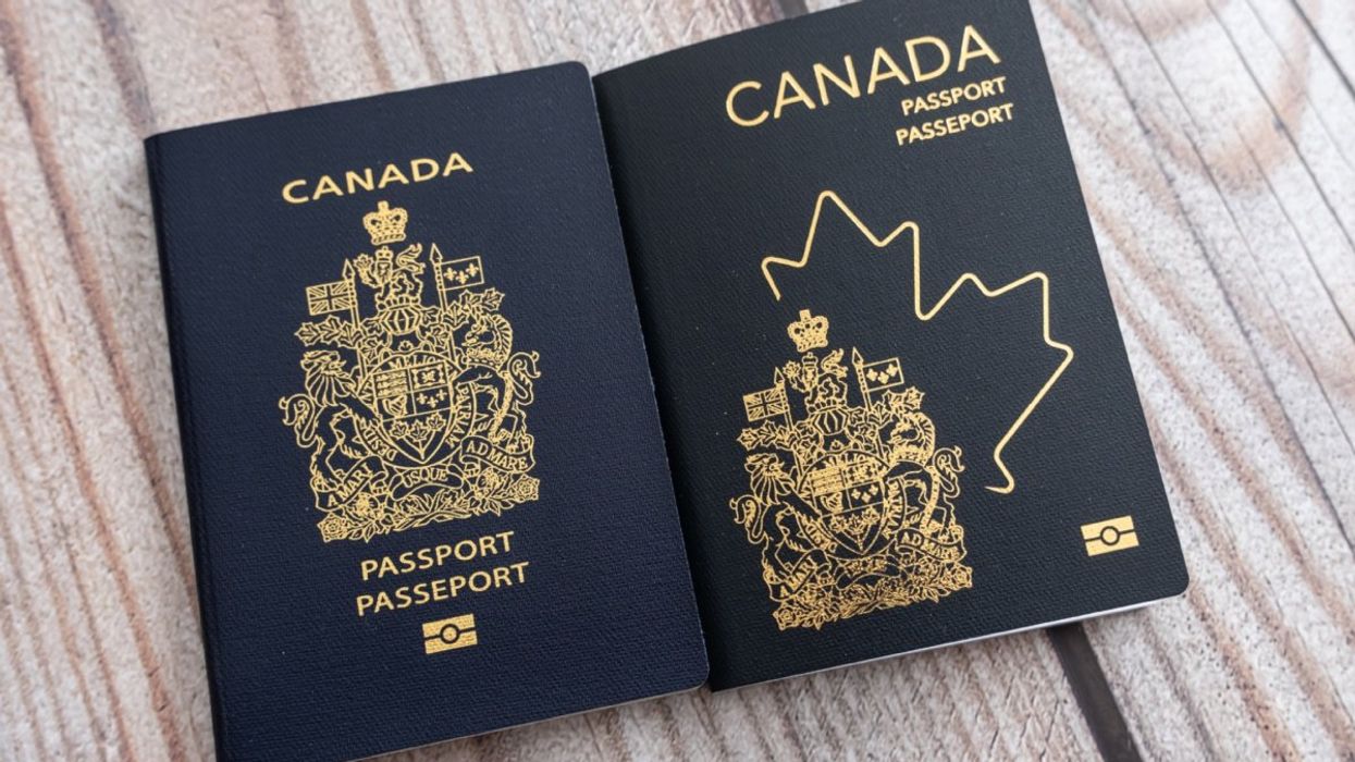 The 2013 version of the Canadian passport beside the 2023 updated version of the Canadian passport on a wooden table.