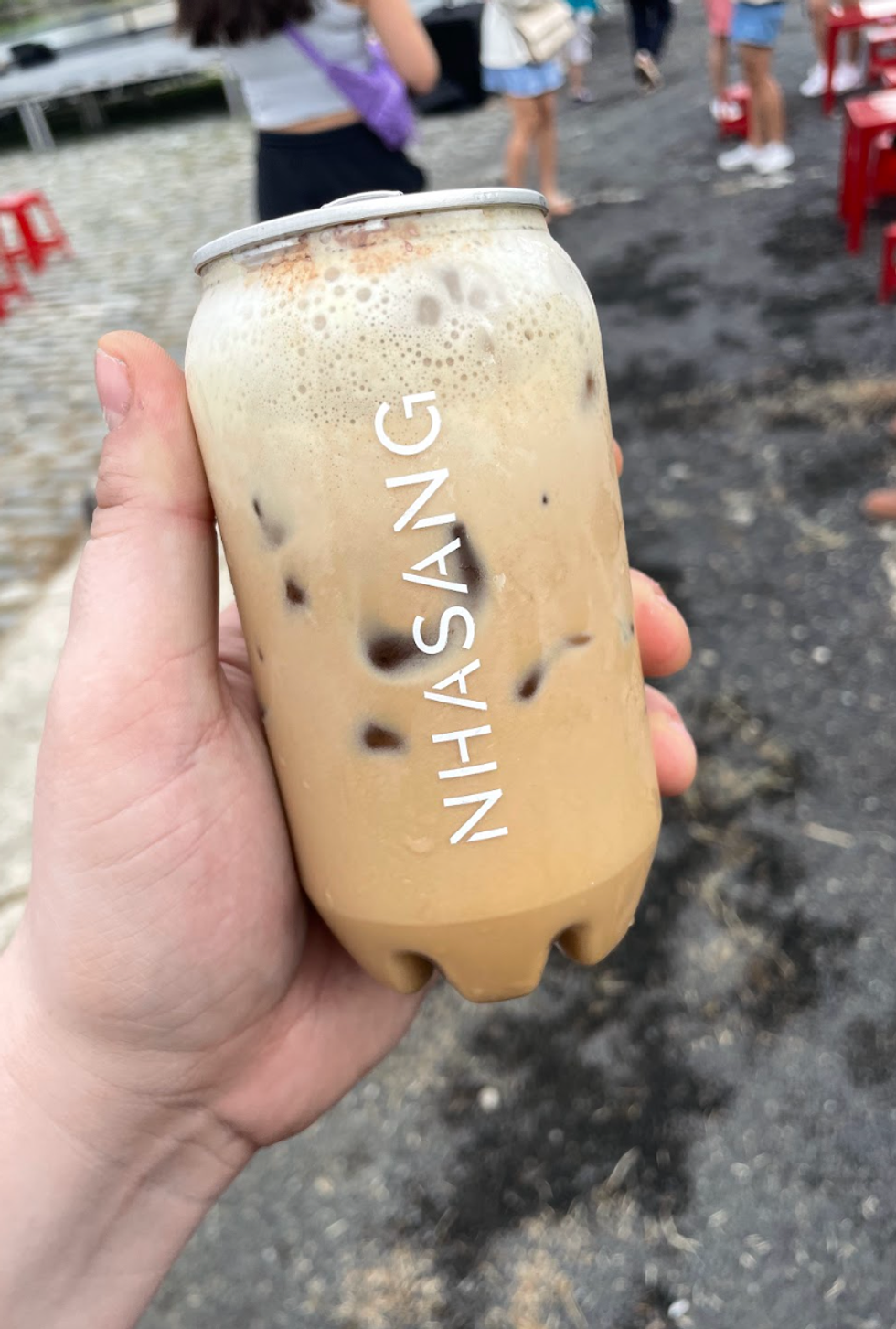 The author holds an iced egg coffee from Nha Sang.