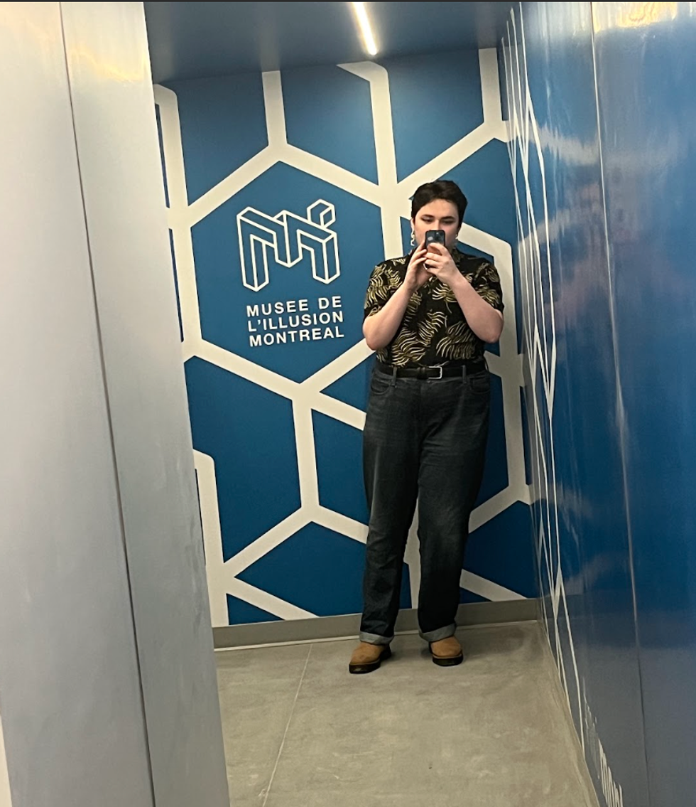 The author stands in a tilted room in which it's impossible to look like you're standing up straight.