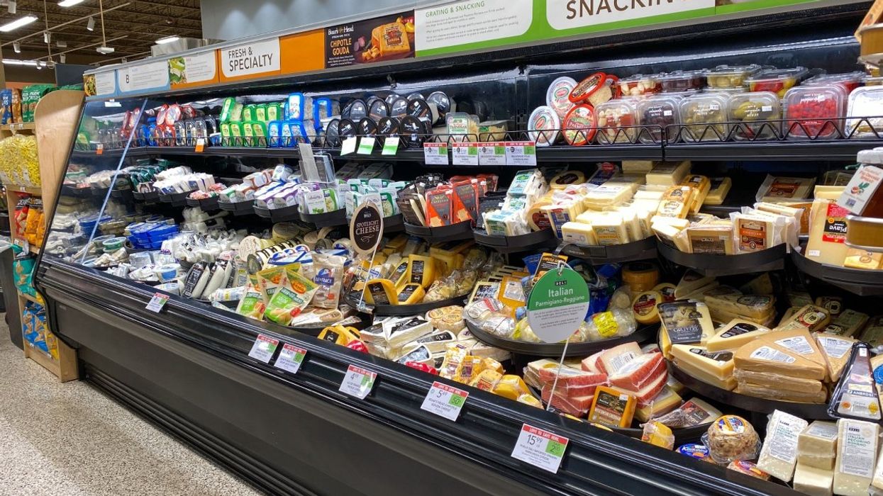 The cheese aisle at a grocery store in Canada featuring various dairy products for snacking, cheeseboards and more.