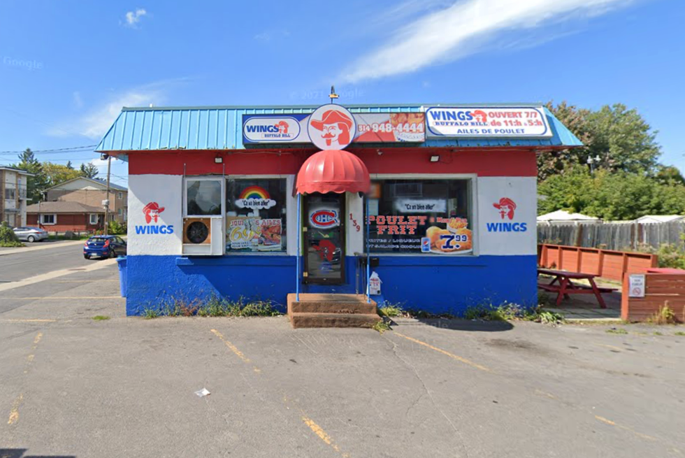 The exterior of a chicken wing restaurant painted in blue, white and red located in Montreal's South Shore.