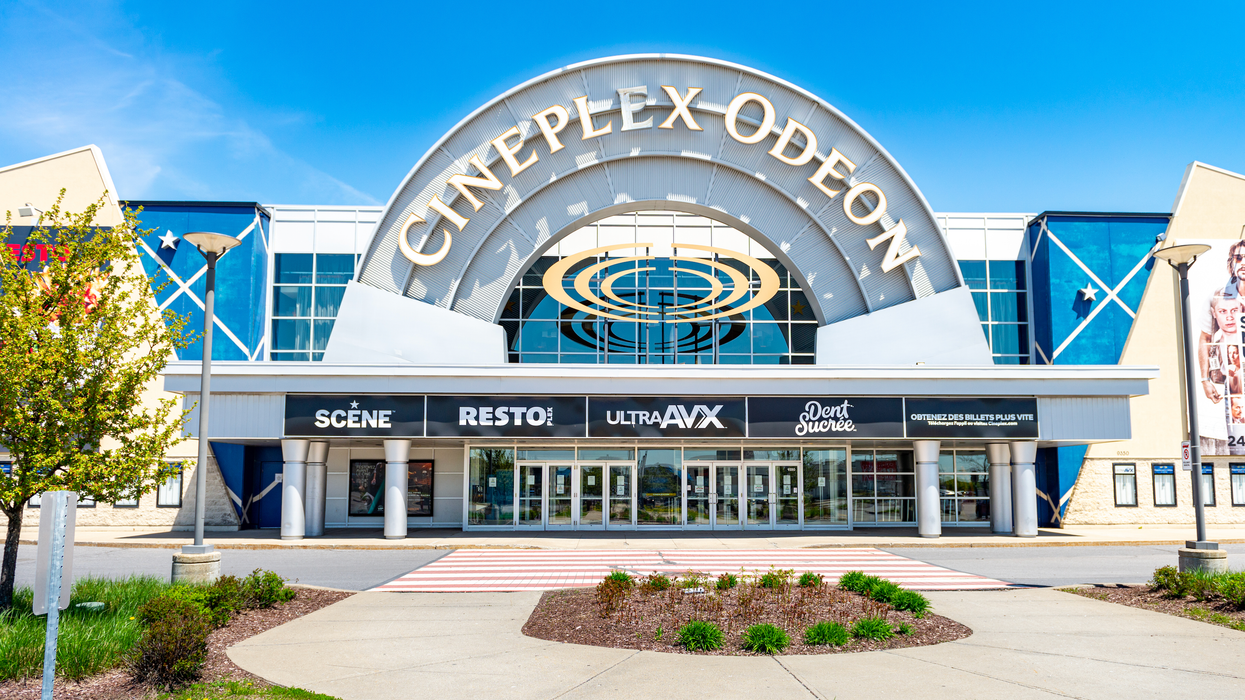 The exterior of a Cineplex Odeon theatre under a clear blue sky.