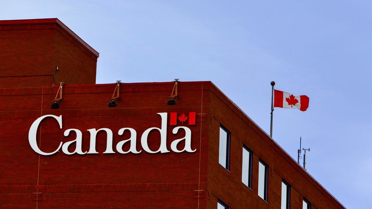 The exterior of a Government of Canada building with a Canadian flag flying on the rooftop.