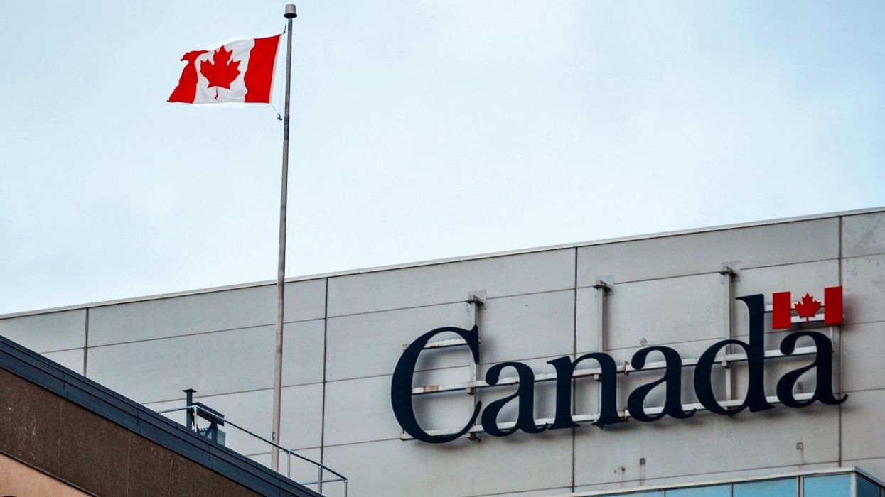 The exterior of a Government of Canada building with the Canadian flag on the rooftop.