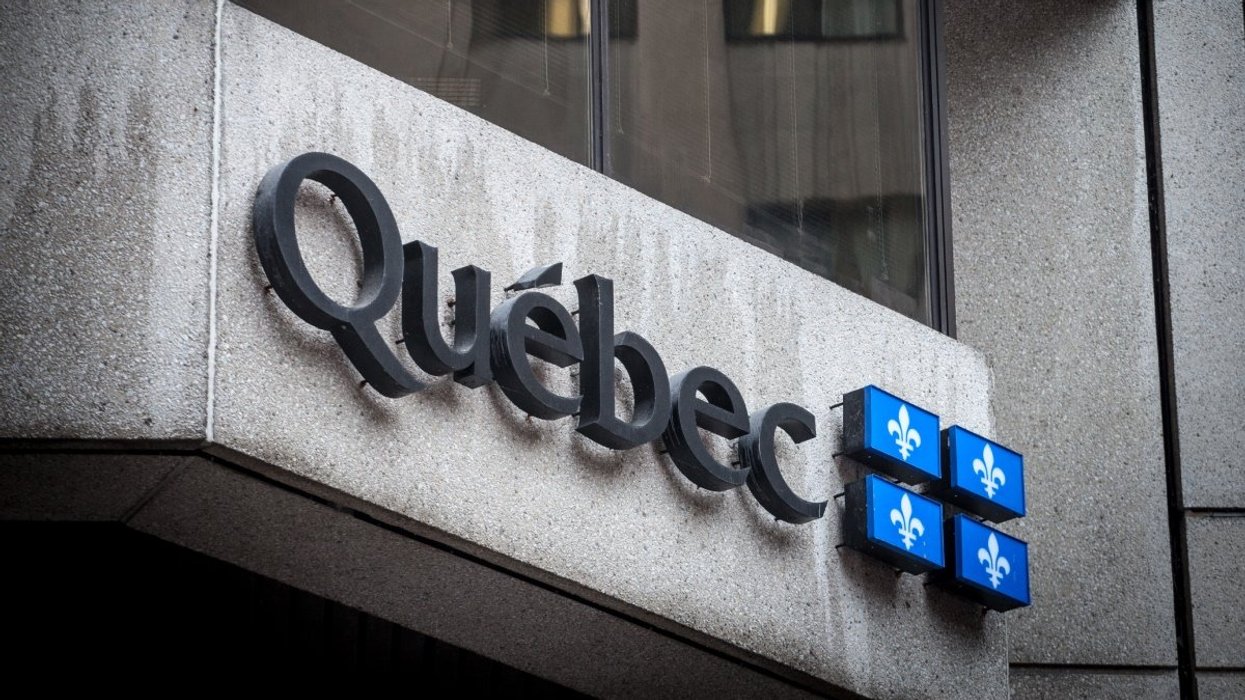 The exterior of a Quebec government building with the Quebec flag.
