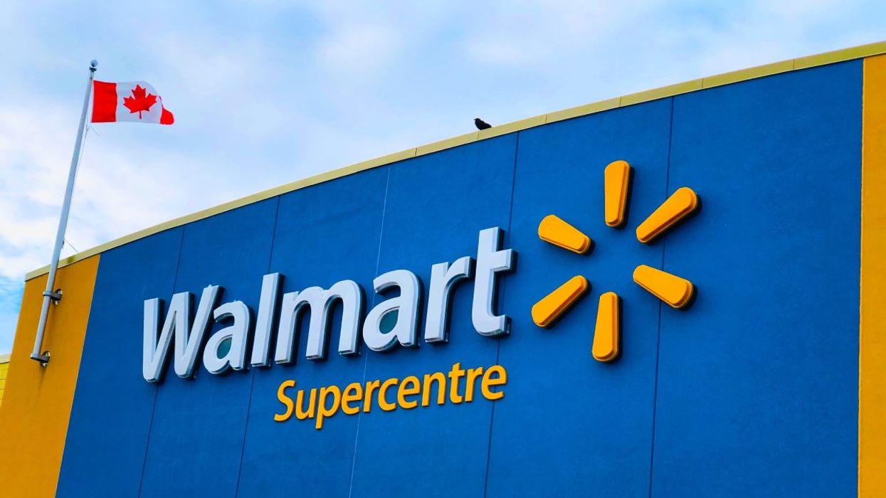 The exterior of a Walmart Supercentre in Canada with the Canadian flag flying on the roof.