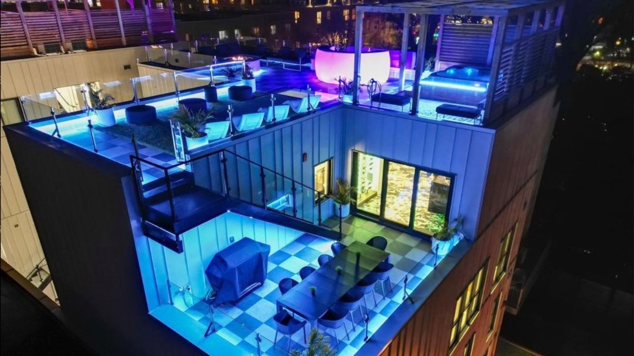The exterior of ClubHaus' VIP penthouse with a rooftop hot tub, dining area, barbecue, fire pit and bar.