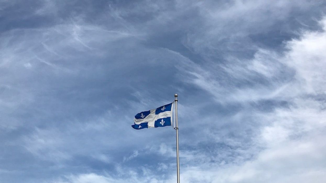 The flag of Quebec against an overcast sky.