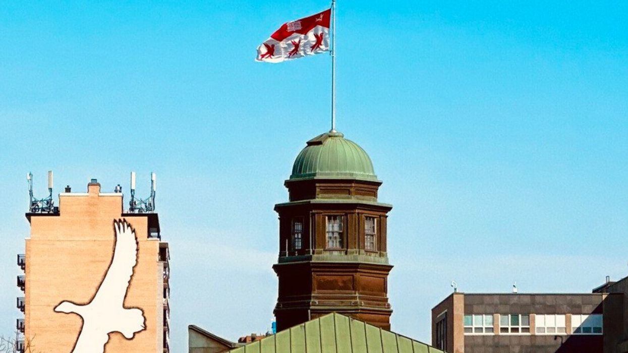 The McGill flag flies atop the Arts building, with a Riopelle mural in the background.