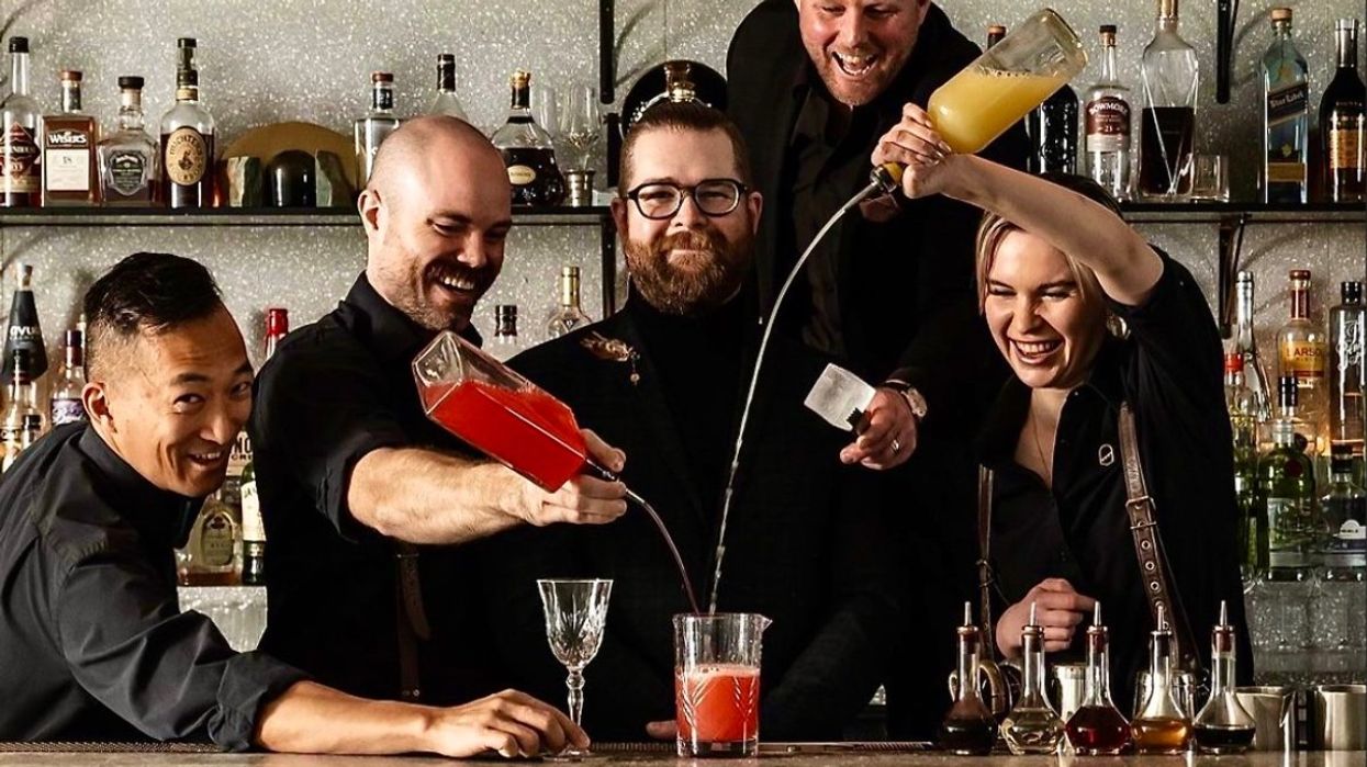 The mixologists behind the bar mixing drinks at The Botanist in Vancouver, BC.