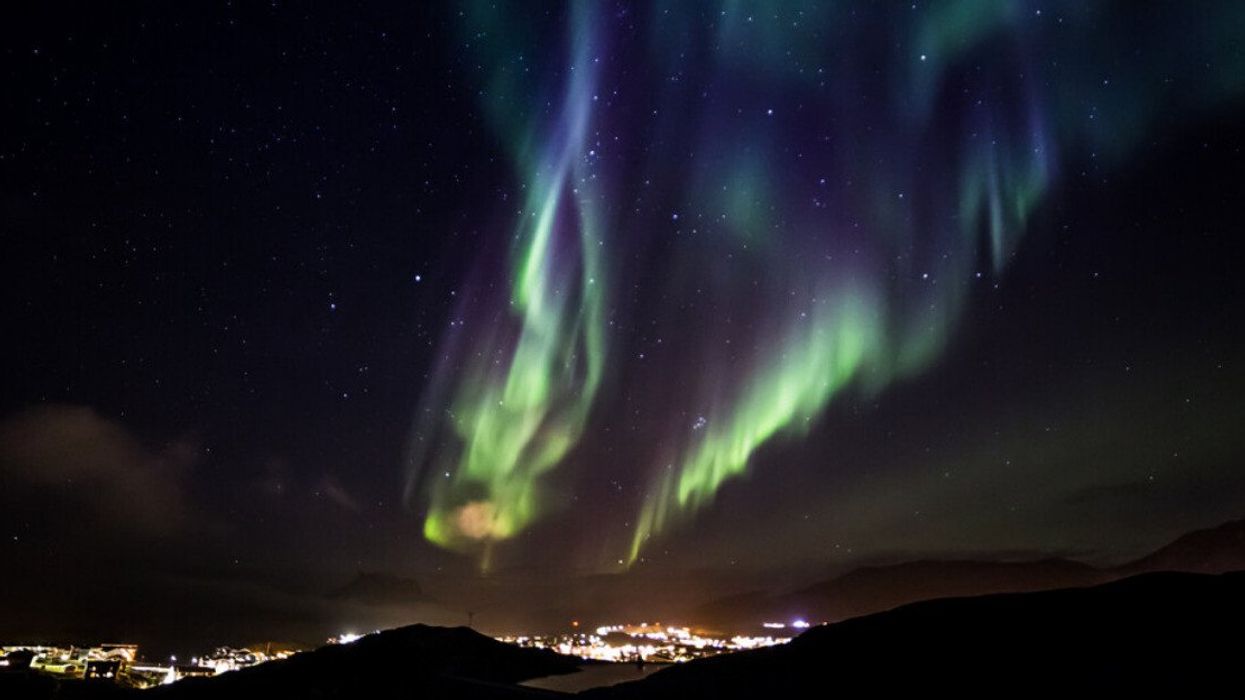 The northern lights over a city.