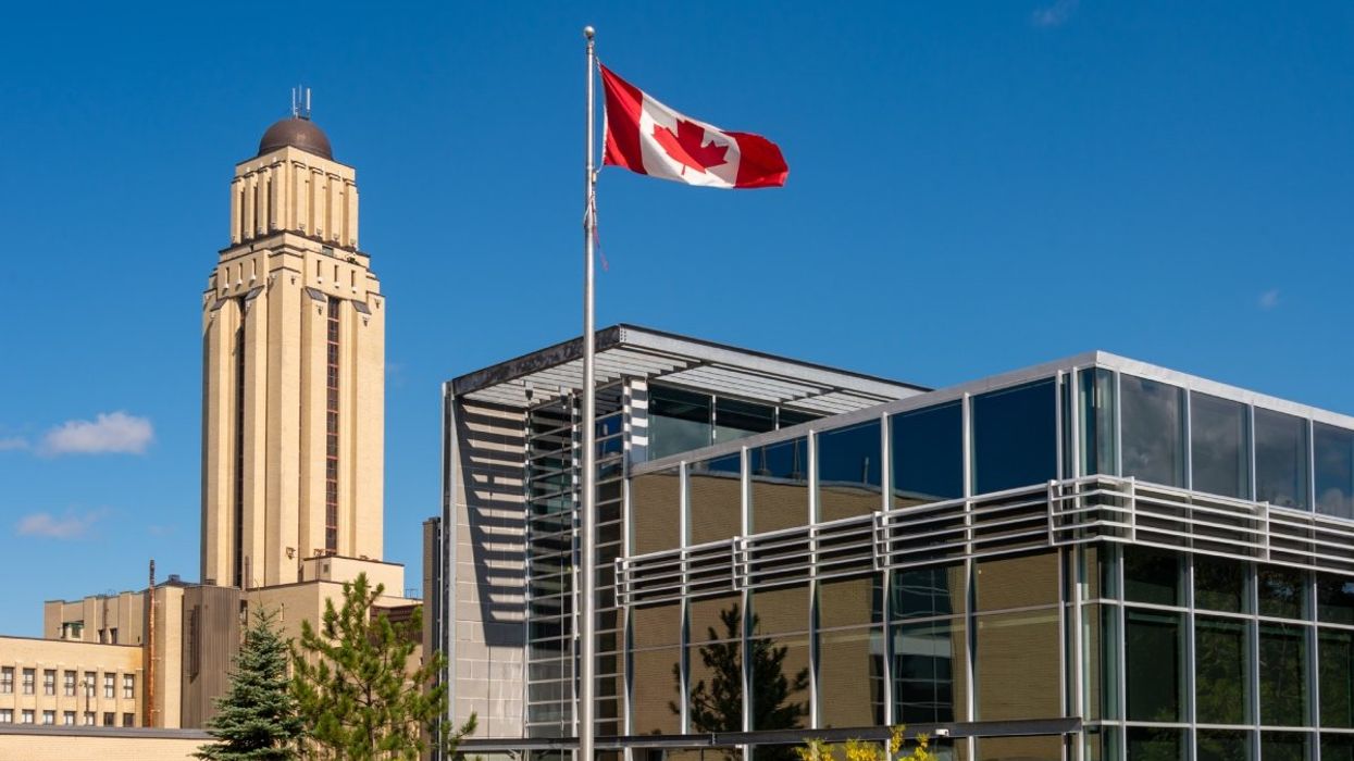 The University of Montreal (UdeM) Pavillon Roger-Gaudry building and a Canadian flag waving during the summer.