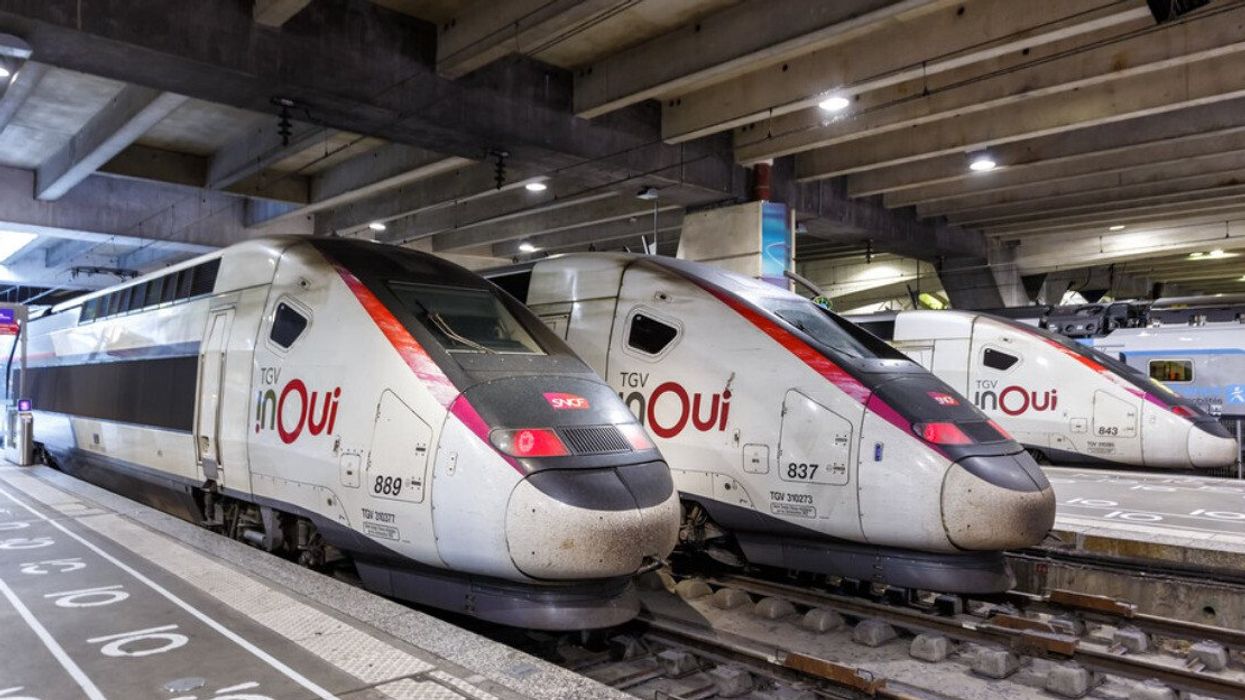 Three high-speed trains in a station.
