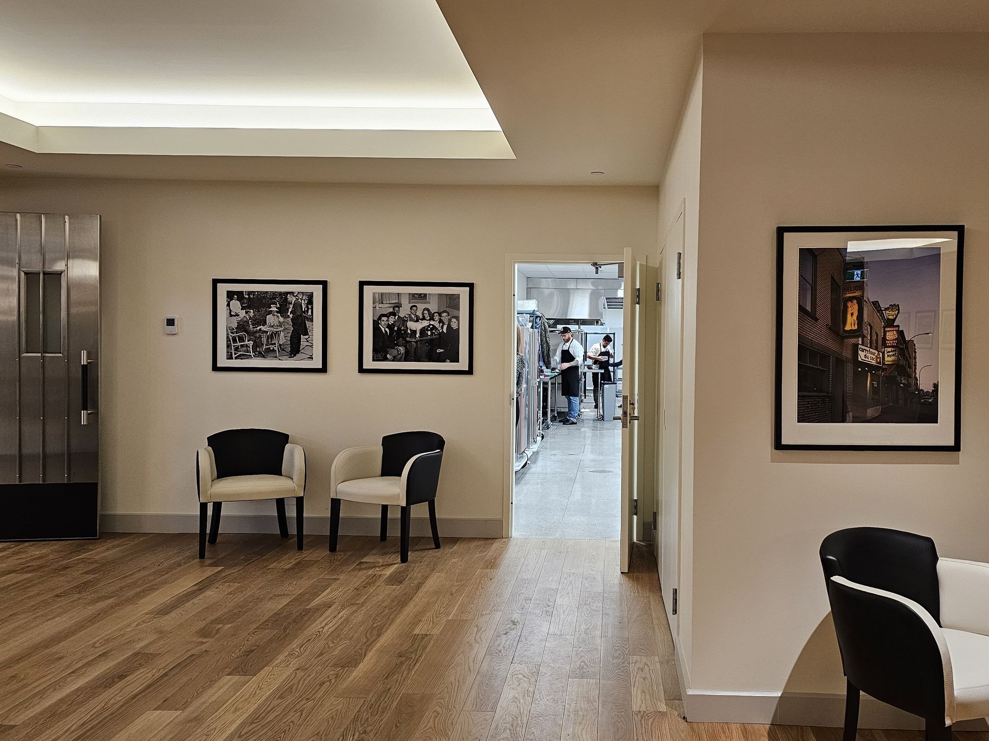 Two chefs in black aprons prepare food in the kitchen of Le 9e.