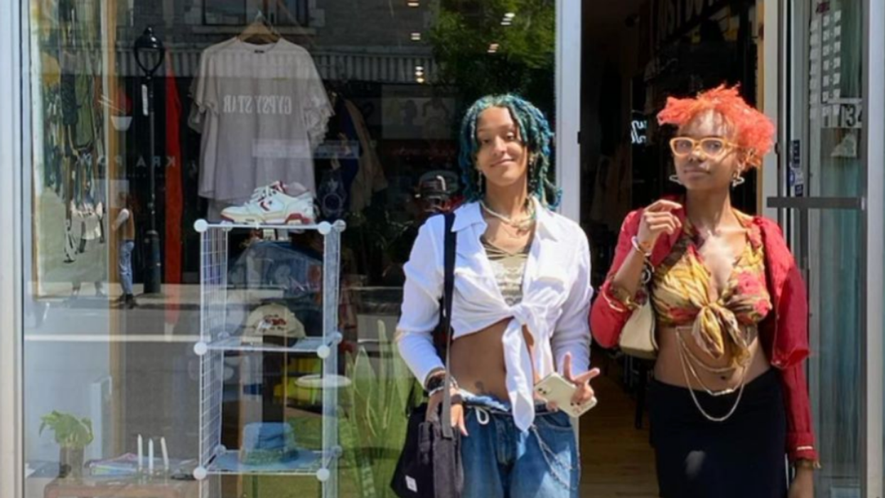 Two Club Theos customers pose in front of the store.