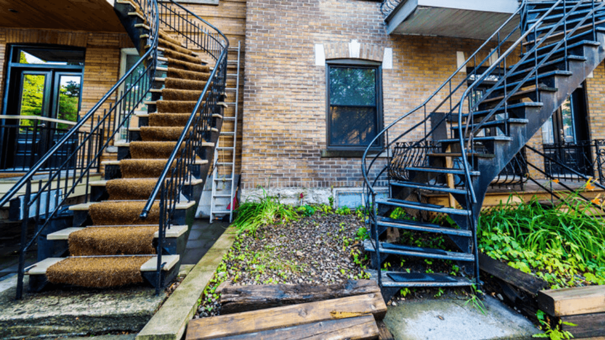 Two exterior iron staircases in front of homes on a typical Montreal street.