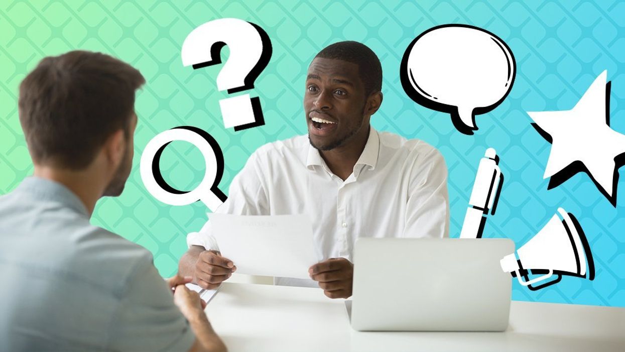 Two people conducting an interview across a desk.