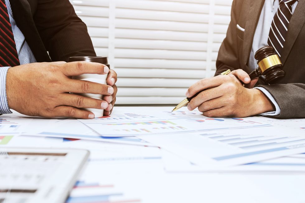Two people look at a pile of papers.