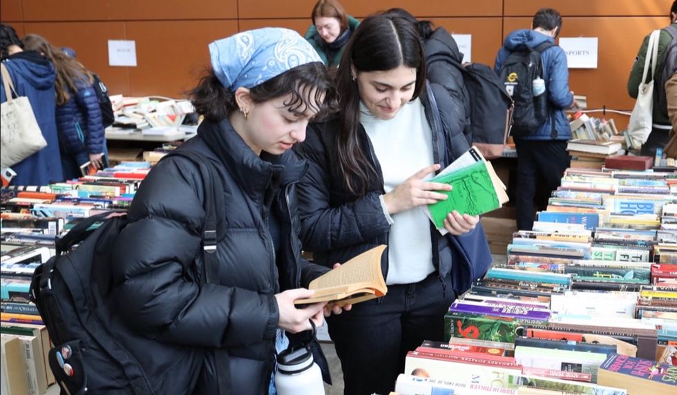 Two people looking through the books at Concordia's used book sale.