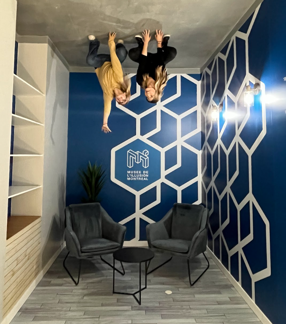 Two people pose in the upside-down room.