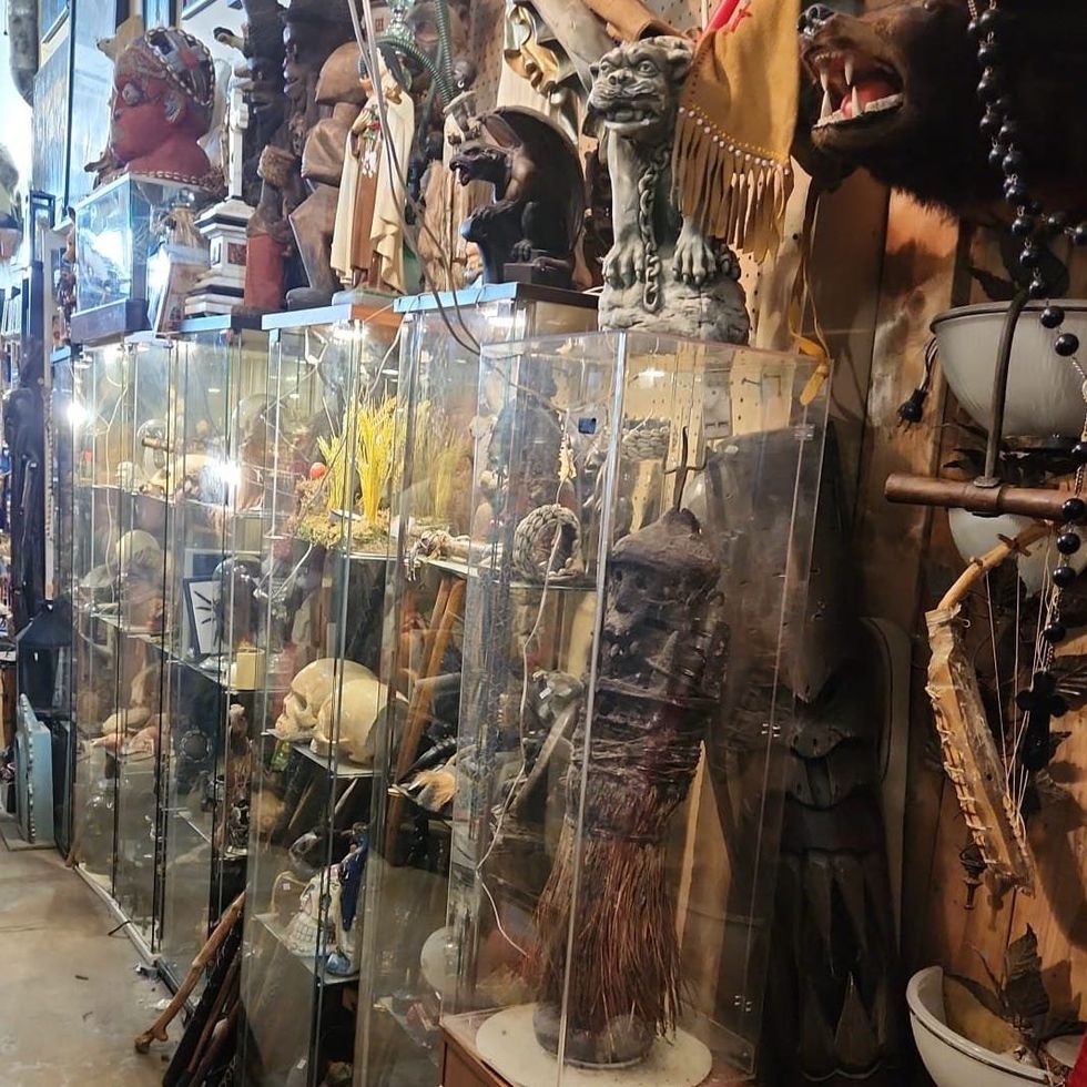 \u200bA collection of ghoulish statues and trinkets in glass cases.