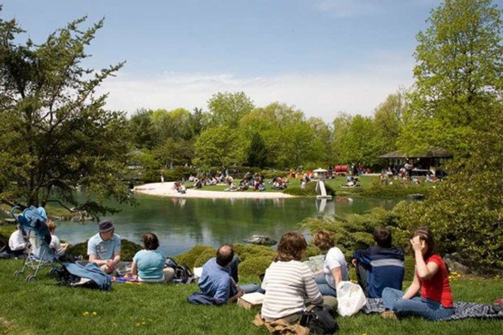 \u200bA crowd picnicking at the Montreal Botanical Garden's Japanese Garden.