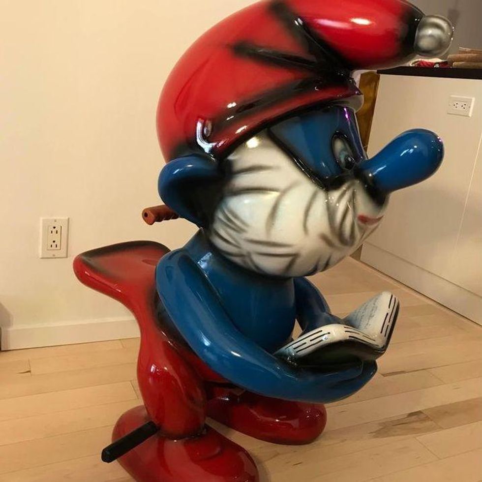\u200bA Papa Smurf ride from a carousel with handles, a seat and pedals.