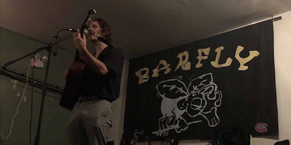 \u200bA person playing guitar at an open mic night at Barfly Montreal.