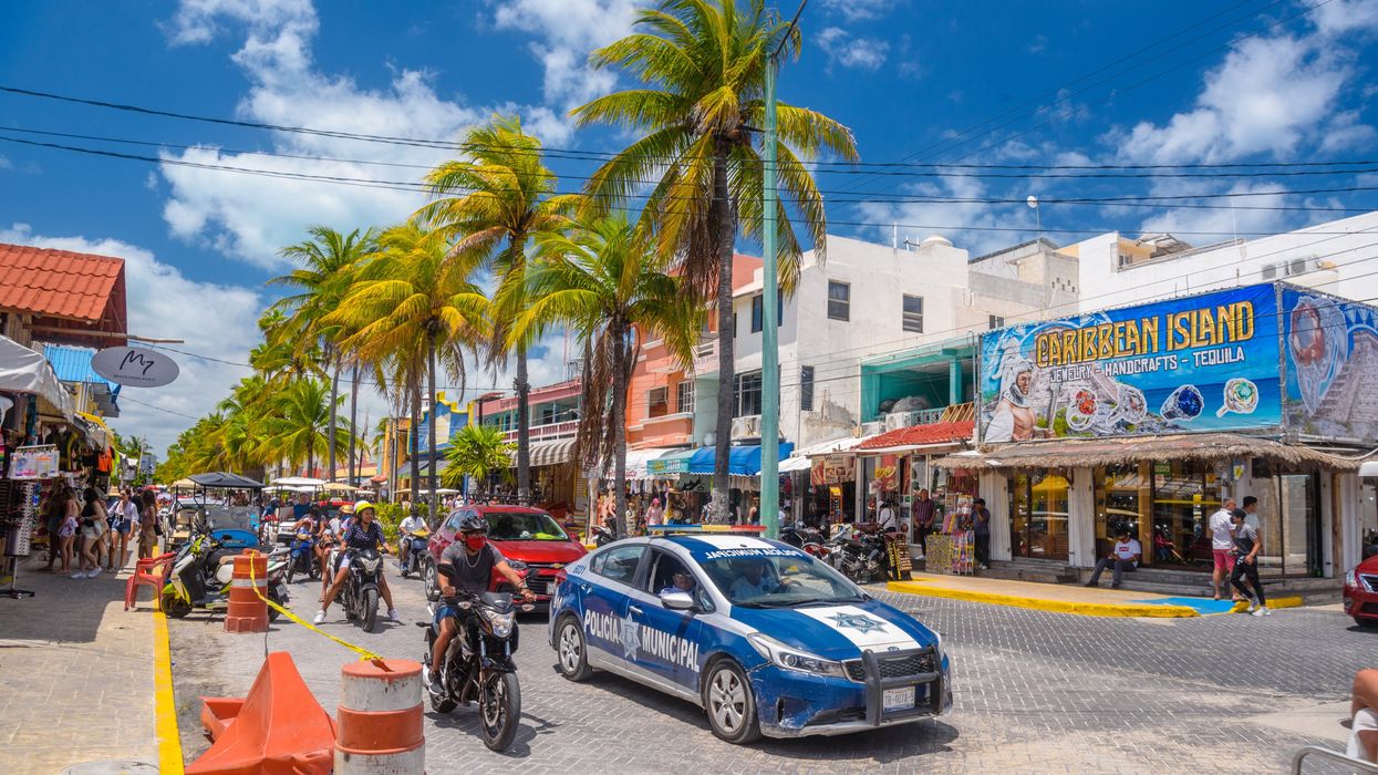 \u200bA police car among palms near Canc\u00fan.
