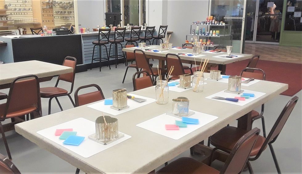 \u200bA table in the candle-making studio with molds, wicks and wax.