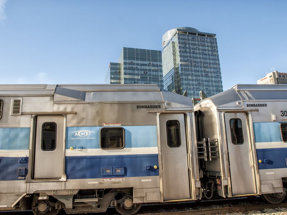 \u200bA train passes in front of a highrise in Montreal.